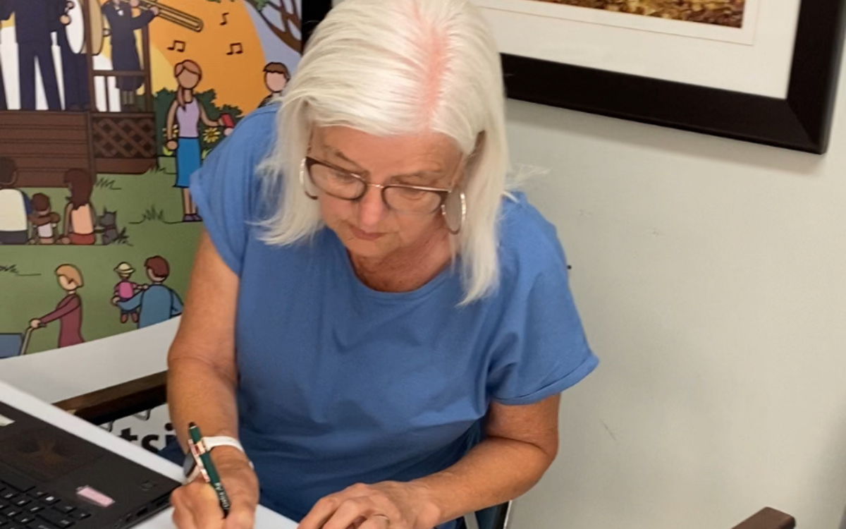woman sitting at desk writing